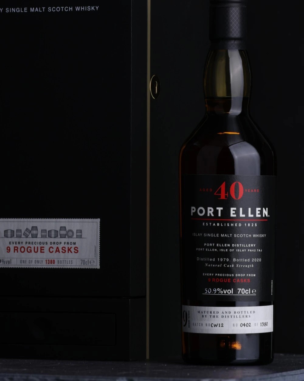 A bottle of Port Ellen 40 Year Old Islay single malt, distilled 1979 and bottled from nine rogue casks, beside its black presentation box against a dark ground.